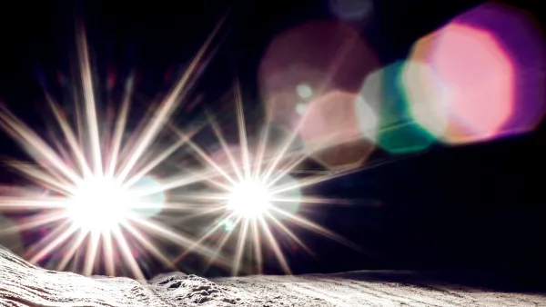 Bright car headlights with glare at night.