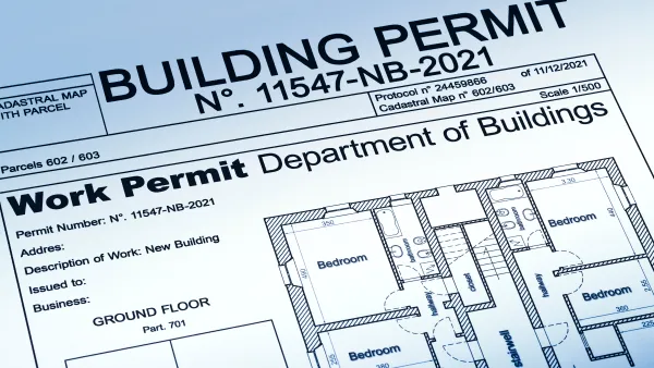 View of a housing permit document with a home blueprint, stamped "approved."
